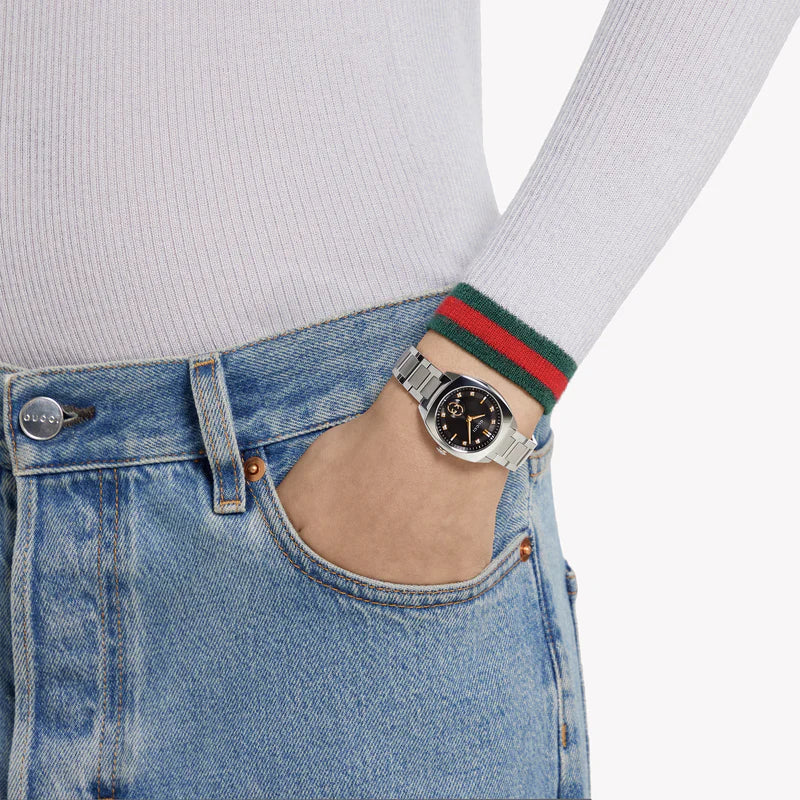 Gucci Interlocking watch worn on wrist with black dial and stainless steel bracelet