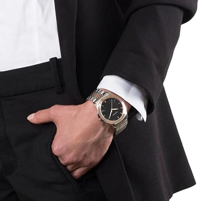 Gucci black dial watch on wrist with two-tone metal band and rose gold bezel