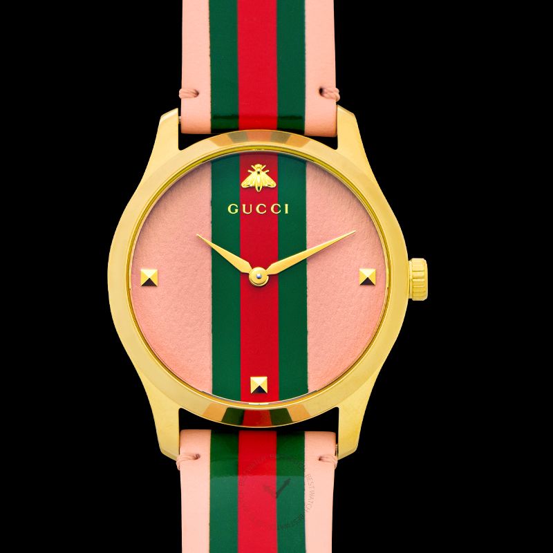Gucci G-Timeless watch face showing pink dial, pyramid studs, and web stripe strap detail