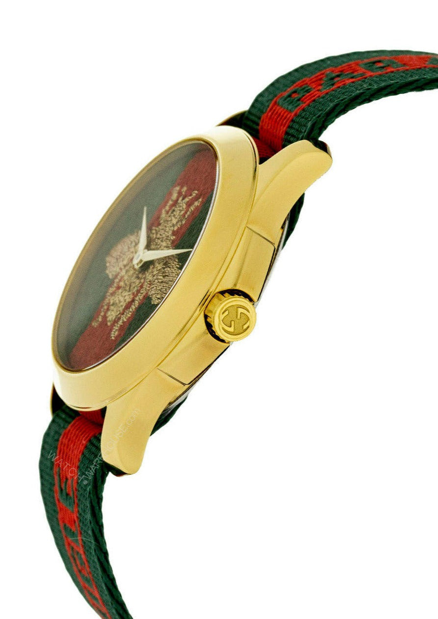 G-Timeless 38mm watch angled view showing gold case, dial with embroidered bee, and striped strap