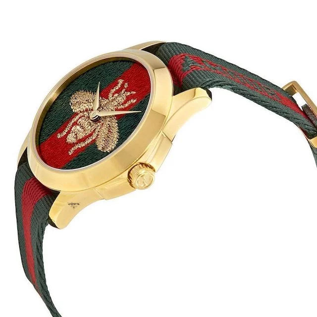 G-Timeless 38mm watch side view with gold case, crown, and green-red striped fabric strap