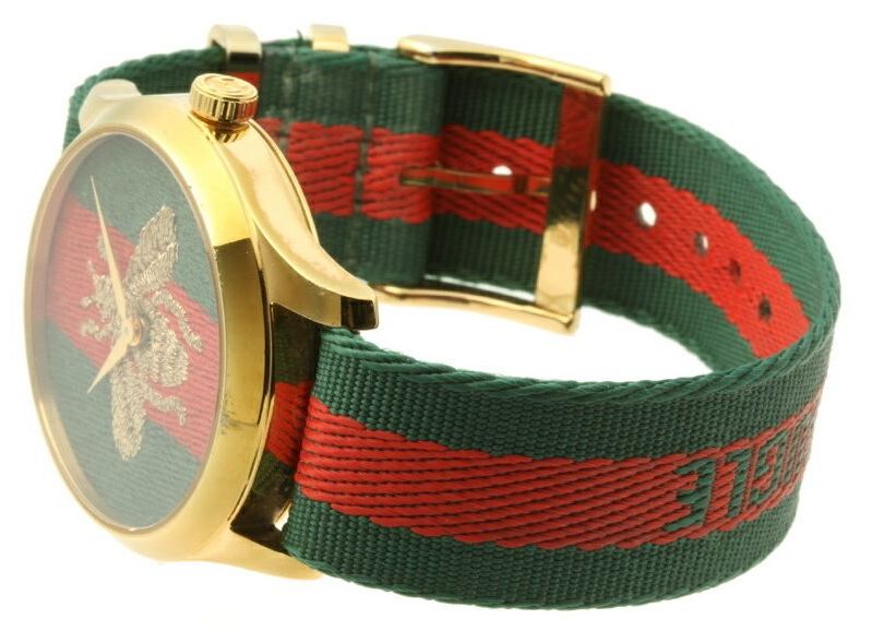 G-Timeless 38mm watch worn on wrist displaying embroidered bee and gold case with striped band