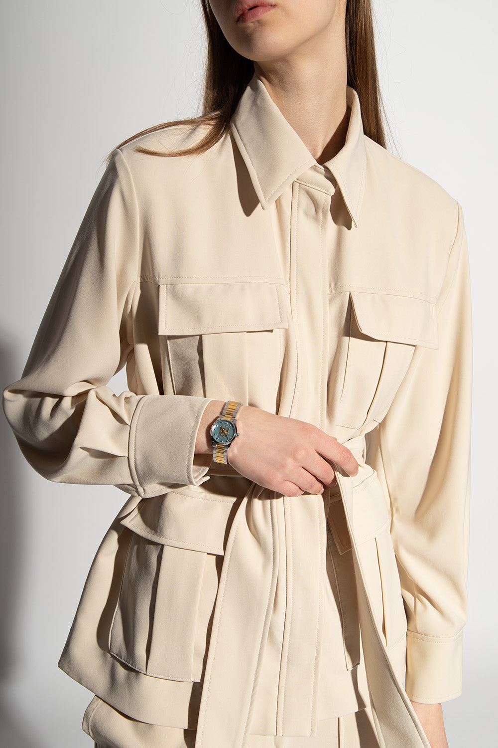 Gucci YA1265011 G-Timeless watch styled on wrist with cream tone clothing