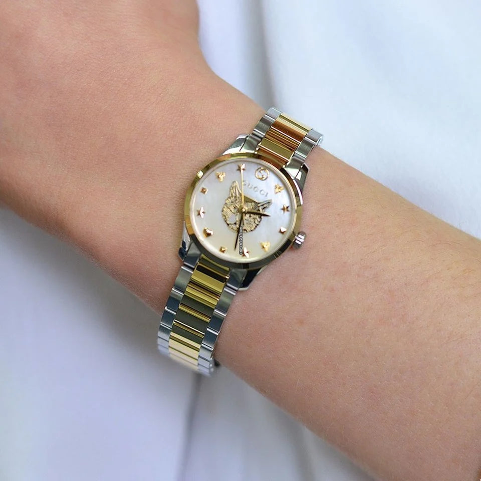 Gucci YA1265011 watch on wrist displaying blue mother of pearl dial and two-tone band