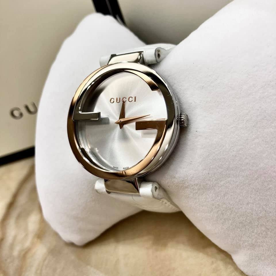 Gucci YA133303 dial detail showing interlocking G design, silver sunburst face, gold accents