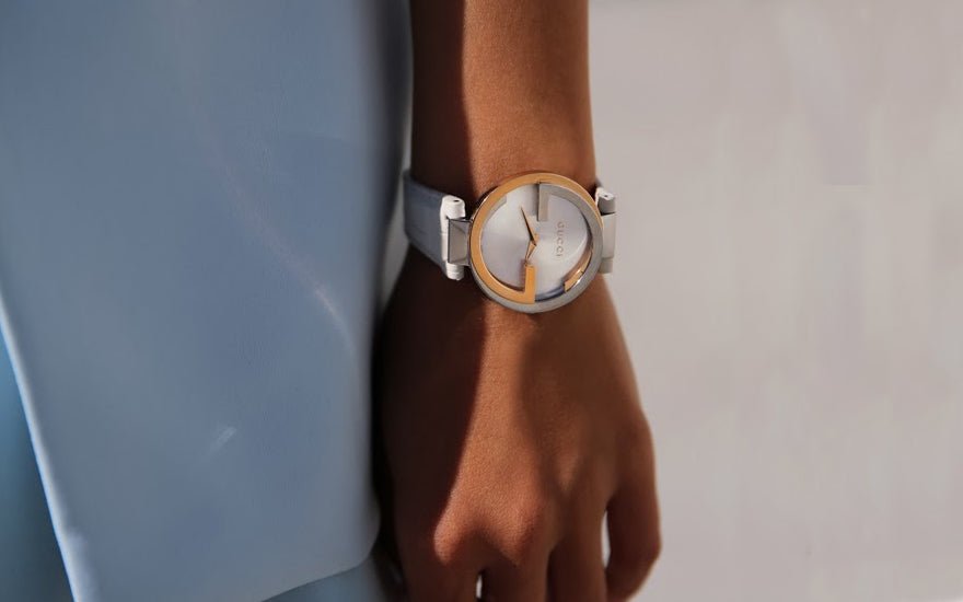 Gucci YA133303 worn on wrist, cream leather strap, gold and steel case visible
