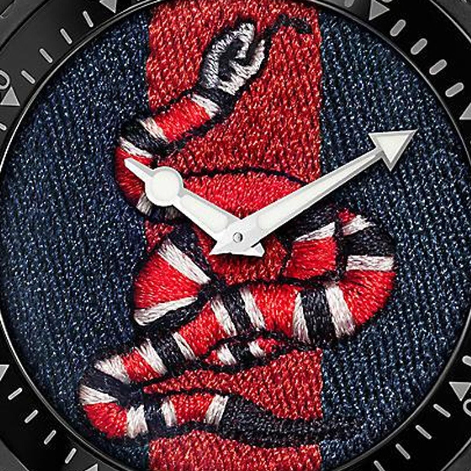 Close-up detail of GUCCI Dive dial showing embroidered red and white snake on navy textile
