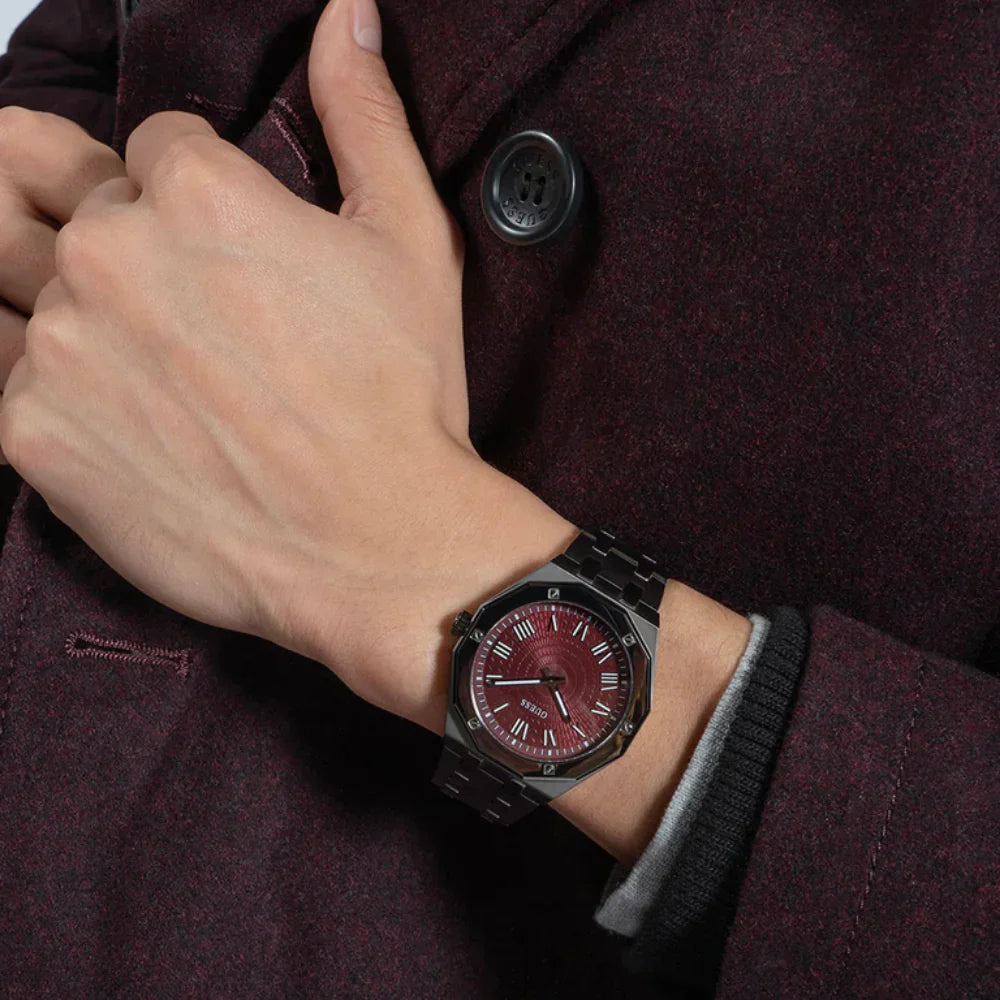 Guess Asset watch worn on wrist with red dial and black steel bracelet