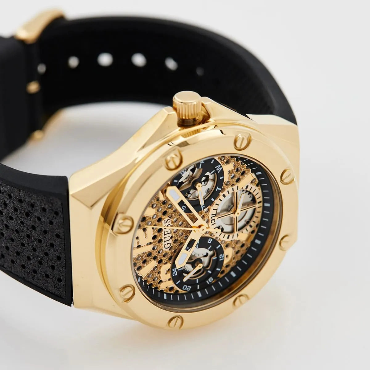 Close-up of Guess Asteria dial showing gold skeleton movement, subdials, and applied indices
