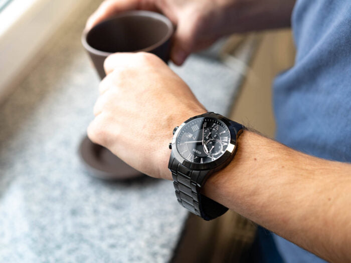 Guess Atlas chronograph watch on wrist with black dial and steel bracelet
