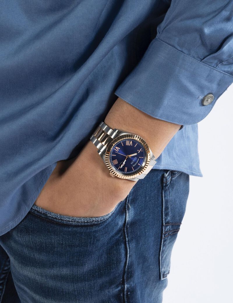Guess Connoisseur watch worn on wrist with blue dial visible