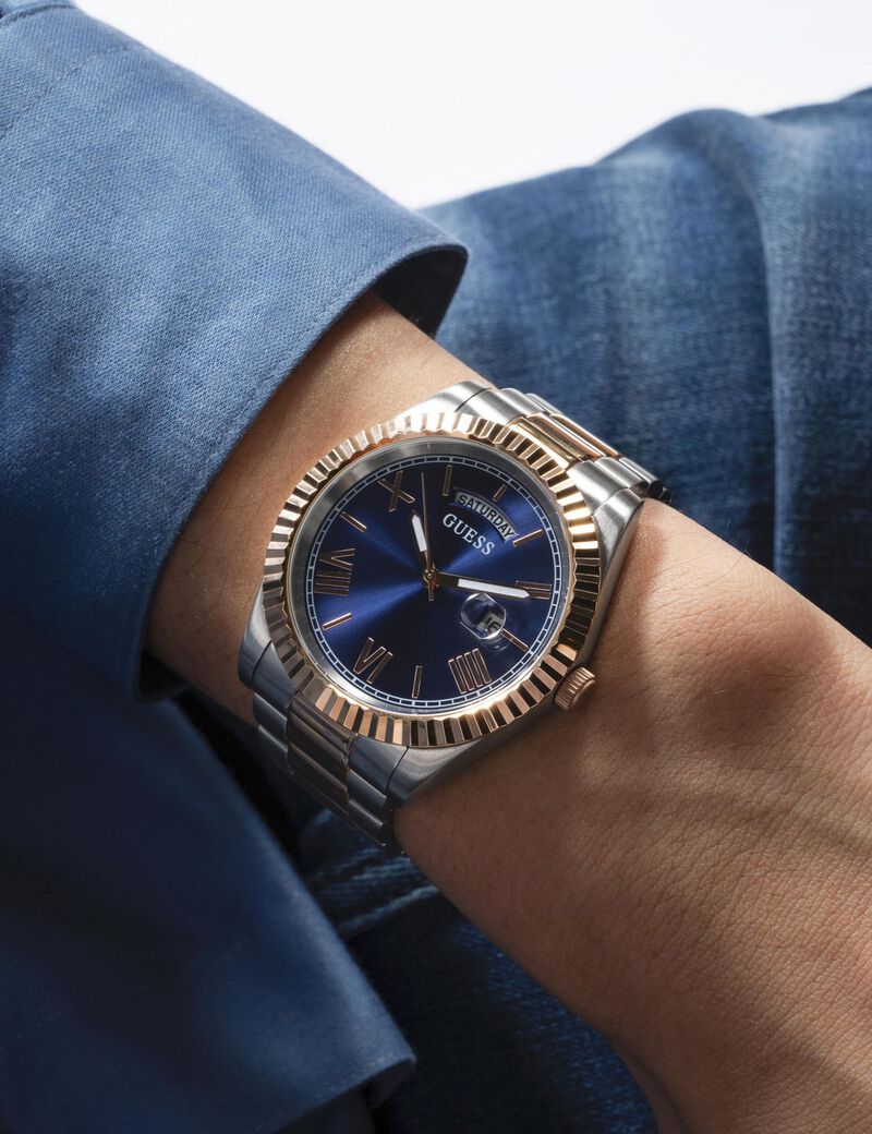 Guess Connoisseur watch worn on wrist displaying two-tone band and dial