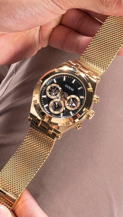 Guess Continental gold chronograph worn on wrist with gold mesh bracelet detail