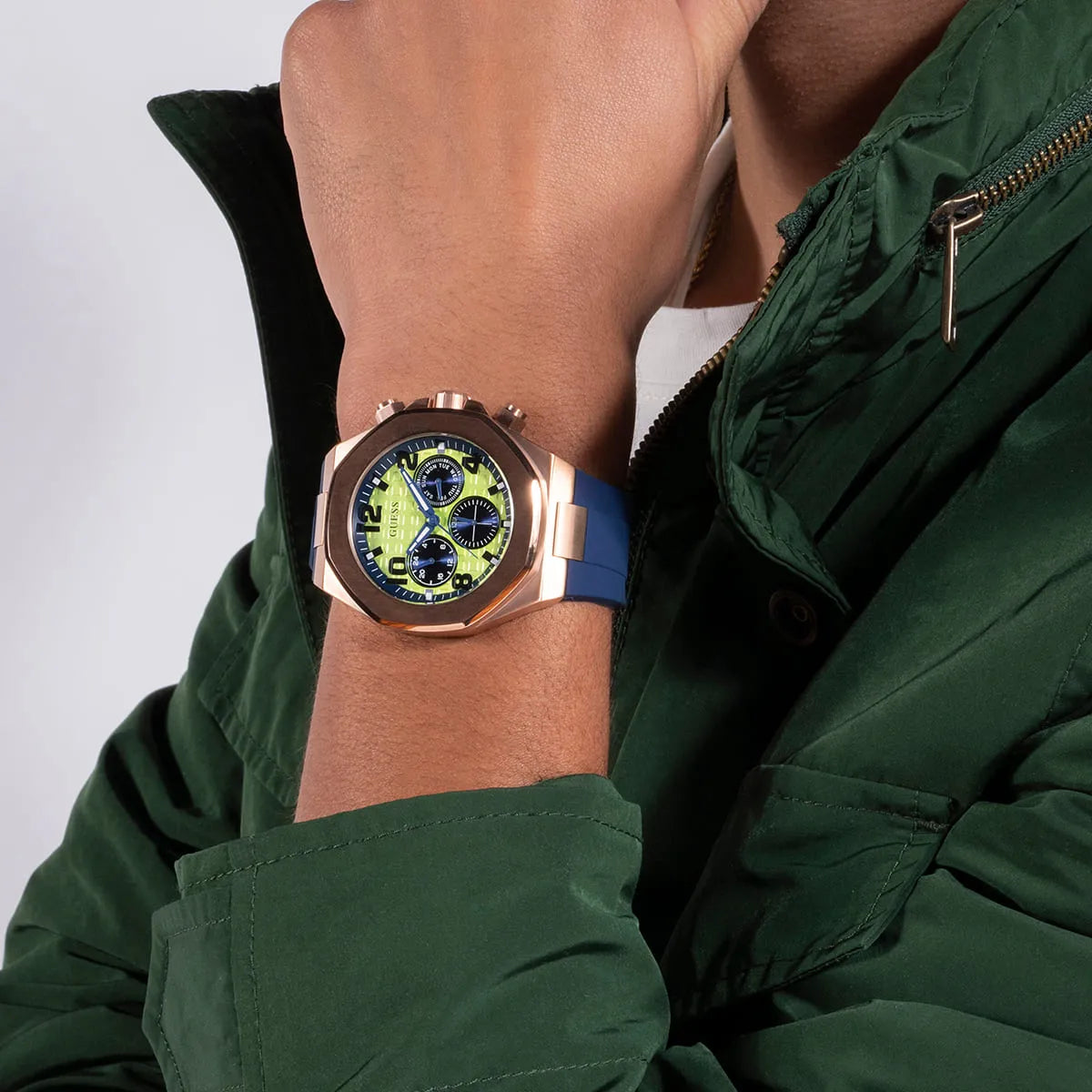 GUESS Empire men's watch on wrist displaying rose gold case and three chronograph subdials