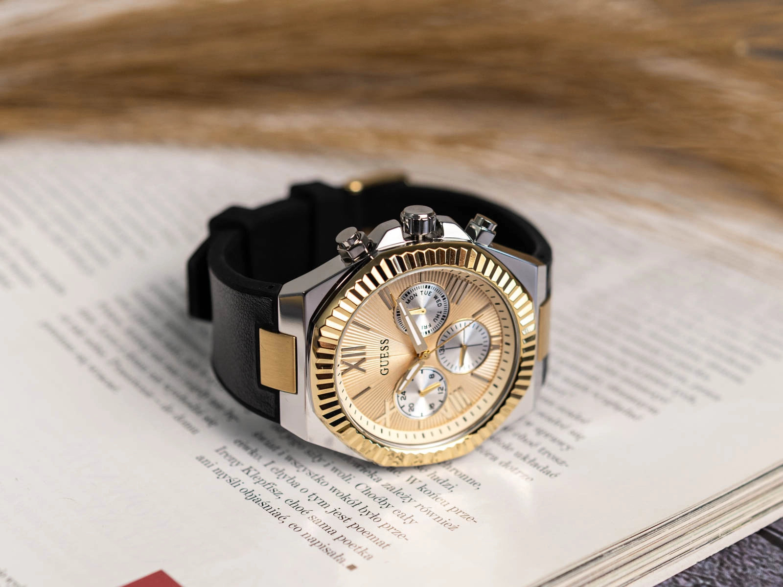 Guess Equity GW0791G1 watch on wrist displaying gold fluted bezel and chronograph dial detail
