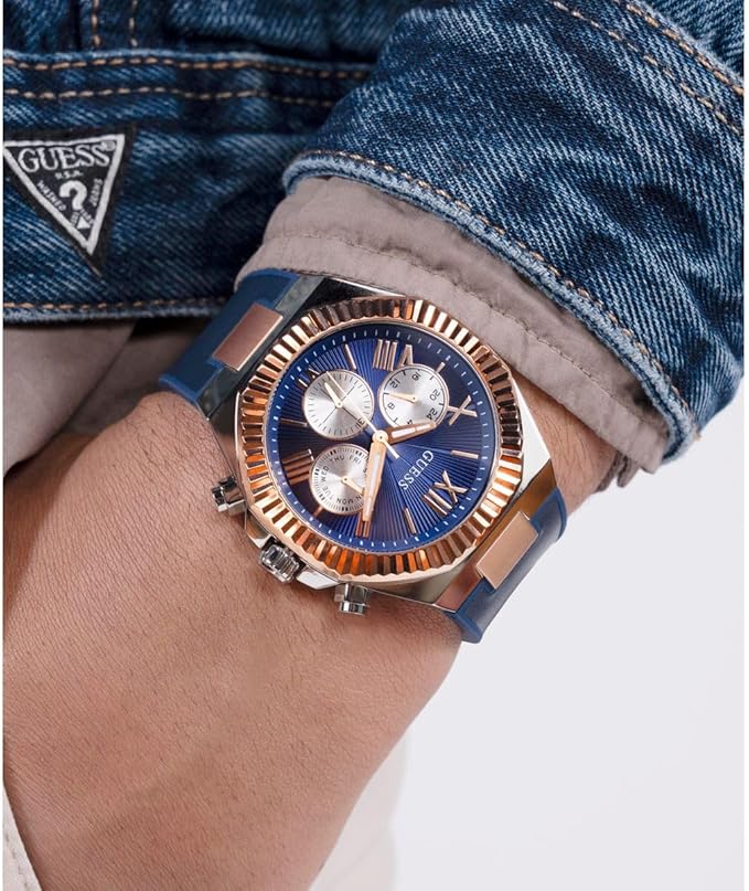 Guess Equity men's watch on wrist showing blue dial with white subdials and rose gold accents