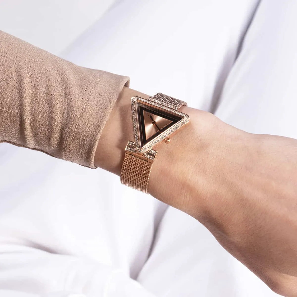 Guess Fame rose gold watch worn on wrist with triangular crystal-set case