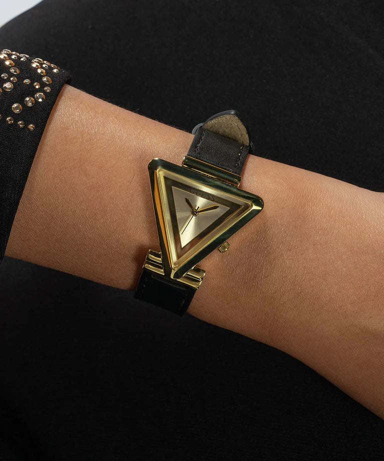 Guess Fame women's watch on wrist showing gold triangle case and black leather band
