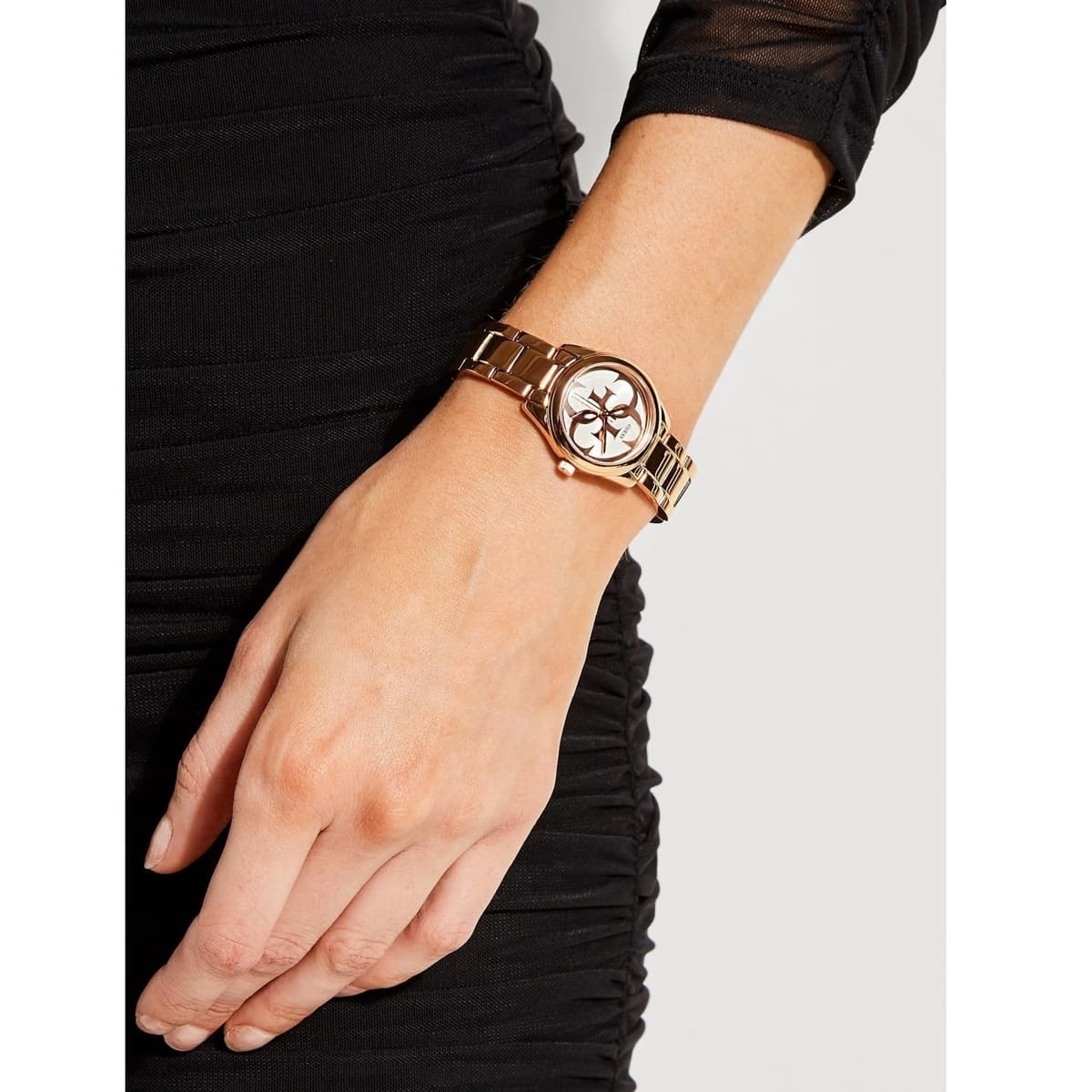 Guess G-Twist gold-tone watch on woman's wrist with round dial visible