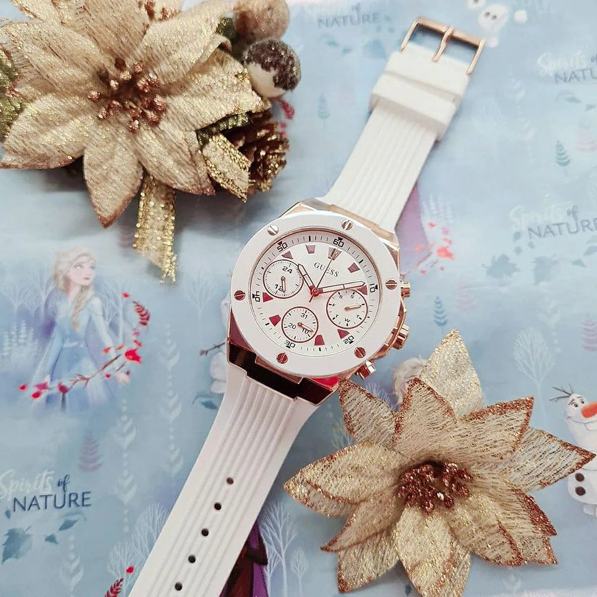 GUESS GW0030L3 watch styled with gold flowers and nature background