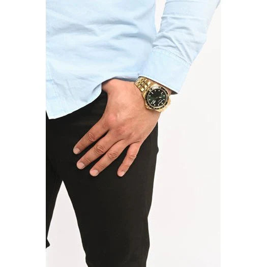 GUESS GW0220G2 gold watch worn on wrist with green dial and black bezel