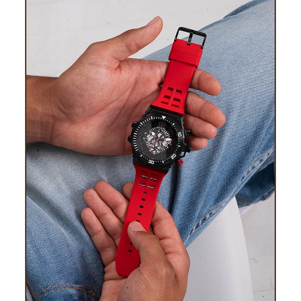 Guess GW0325G3 watch held in hand displaying red strap detail and cutout design