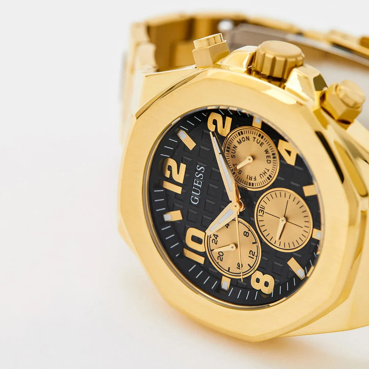 GUESS GW0489G2 dial detail showing black face, gold numerals, and three chronograph subdials