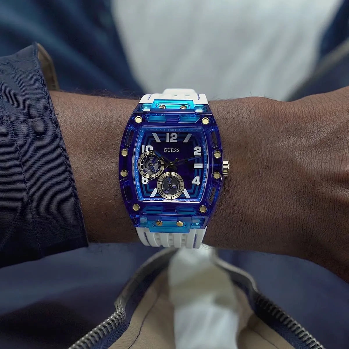 GUESS GW0499G6 watch worn on wrist, blue case with multi-function dial and white strap