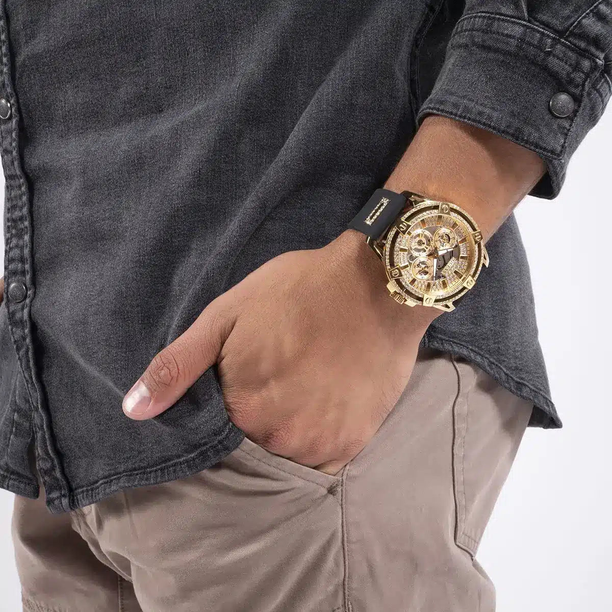 Guess GW0536L3 watch on wrist with champagne dial visible, worn with denim and tan pants