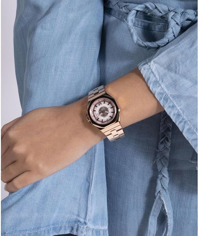 GUESS GW0551L3 rose gold 34mm watch worn on wrist with denim sleeve