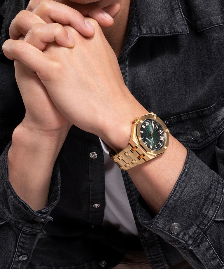 GUESS GW0575G2 gold watch worn on wrist with green dial visible