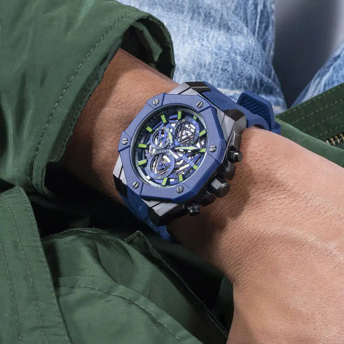 GUESS GW0579G3 blue skeleton dial watch worn on wrist in casual outfit