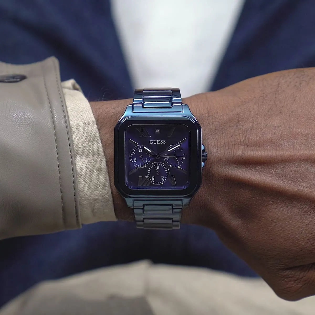 Guess GW0631G3 blue watch worn on wrist with formal attire and light-colored jacket