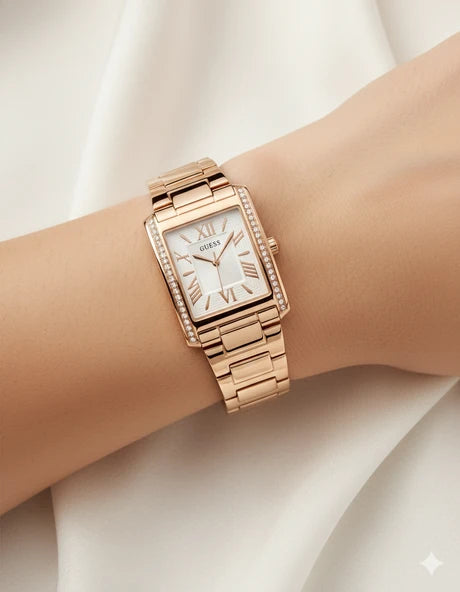 Guess GW0874L3 gold watch on wrist showing rectangular face with Roman numerals and crystal bezel