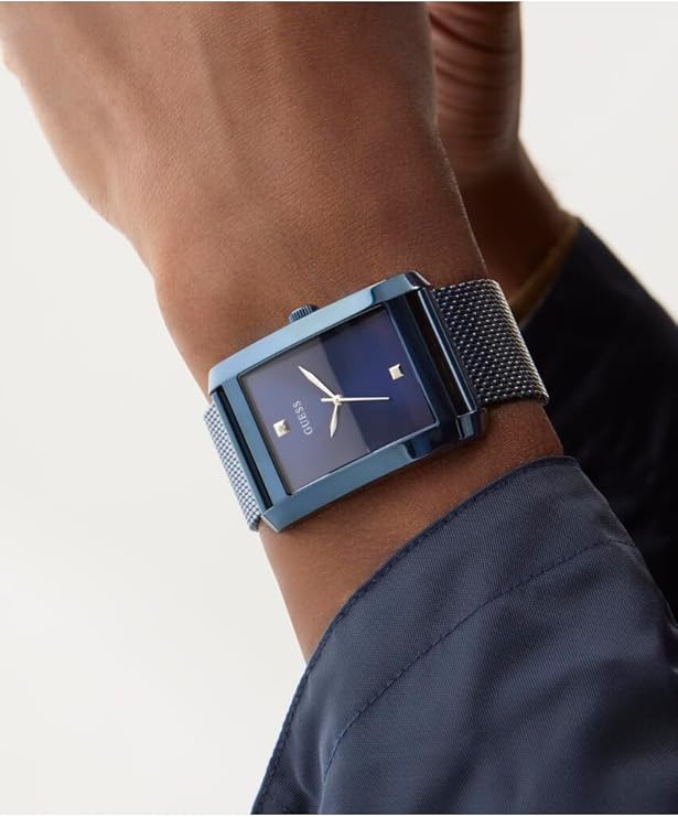 GUESS blue analog watch worn on wrist with blue mesh strap and dark outfit