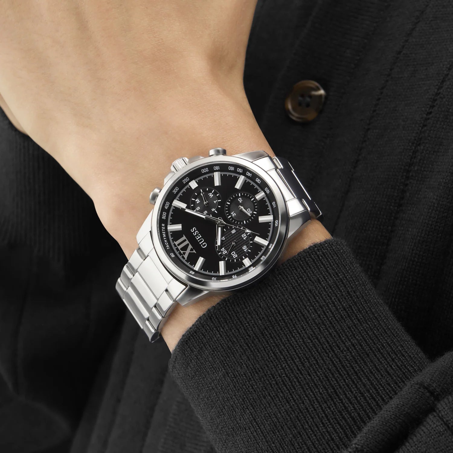 GUESS GW0900G1 chronograph watch on wrist in formal attire with pushers visible