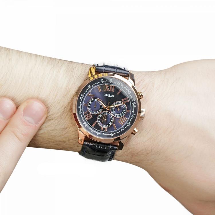 Guess Horizon chronograph watch worn on wrist showing blue dial and navy leather strap