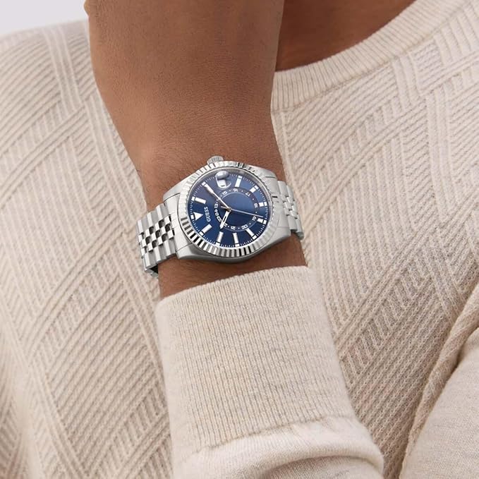 GUESS Jaden watch worn on wrist showing silver tone bracelet and blue dial