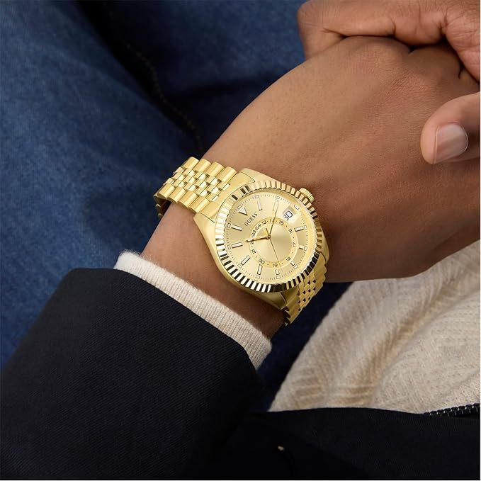 GUESS Jaden gold tone watch worn on wrist with gold bracelet
