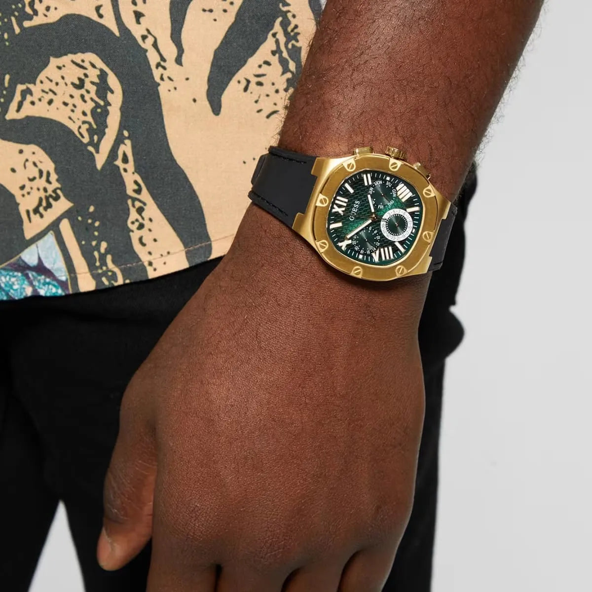Guess Legacy gold chronograph watch on wrist showing green dial
