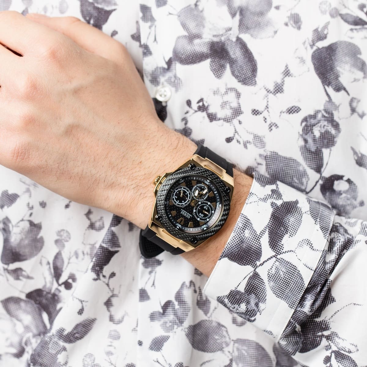 Guess Legacy watch on wrist with chronograph subdials and gold-tone case