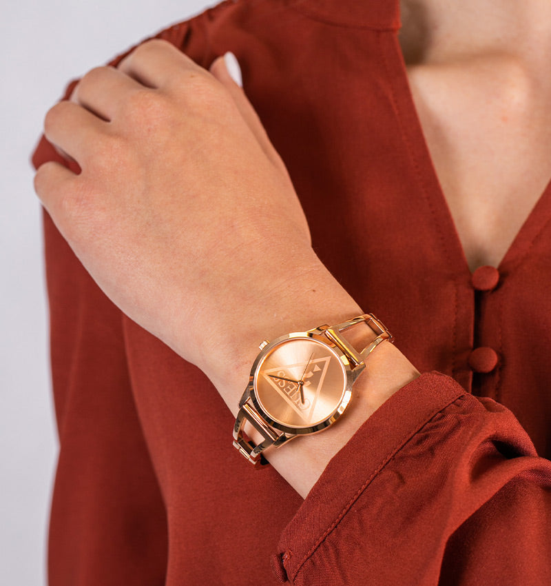 Guess Lola rose gold watch on wrist with red sleeve, side angle view