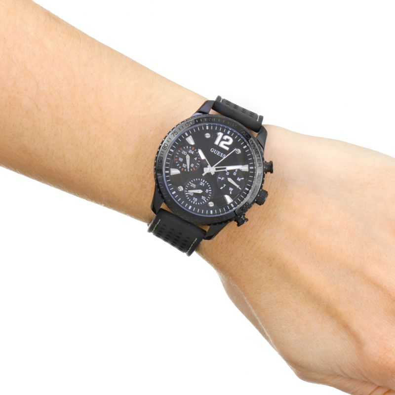 Guess Marina black chronograph watch worn on wrist with black perforated strap