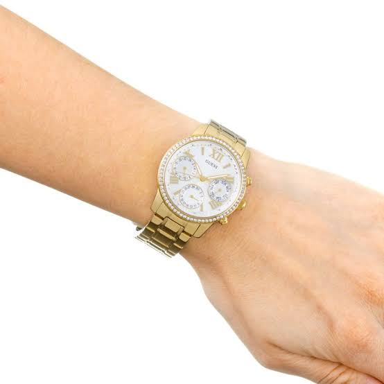 Guess Mini Sunrise gold watch on wrist showing white dial with three subdials