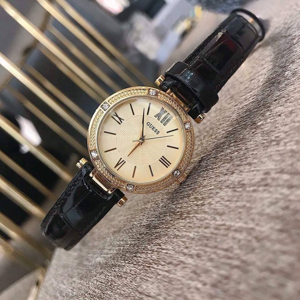 Side angle view of Guess Park Ave South watch showing crystal-set bezel and gold dial