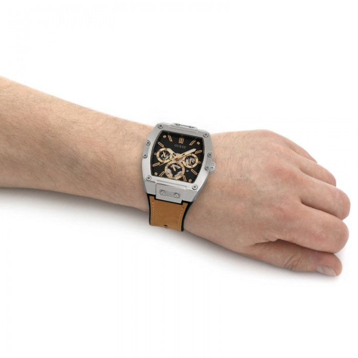Guess Phoenix men's watch worn on wrist with black dial and gold subdials visible