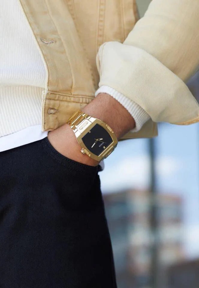 Guess Phoenix watch worn on wrist with black dial and gold case