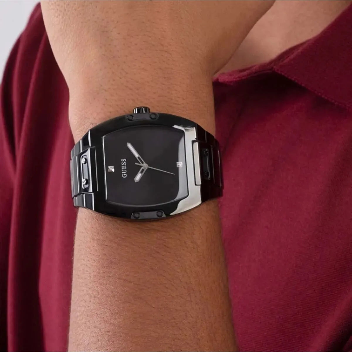 Guess Phoenix men's watch worn on wrist with burgundy sleeve, side-on view
