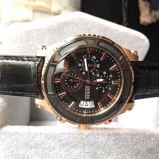 Guess Pinnacle Chronograph watch at angle showing black dial with rose gold accents and chronograph subdials