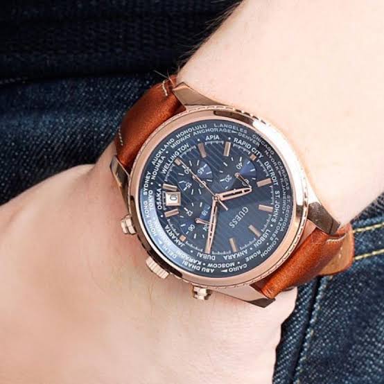 Guess Pursuit chronograph watch on wrist with blue dial and brown leather strap